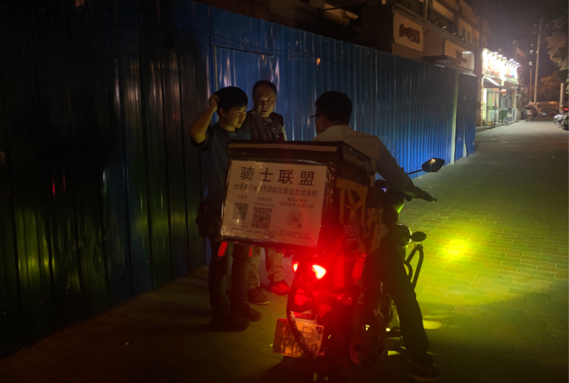聚会结束,陈国江与骑手告别。李一鸣 摄